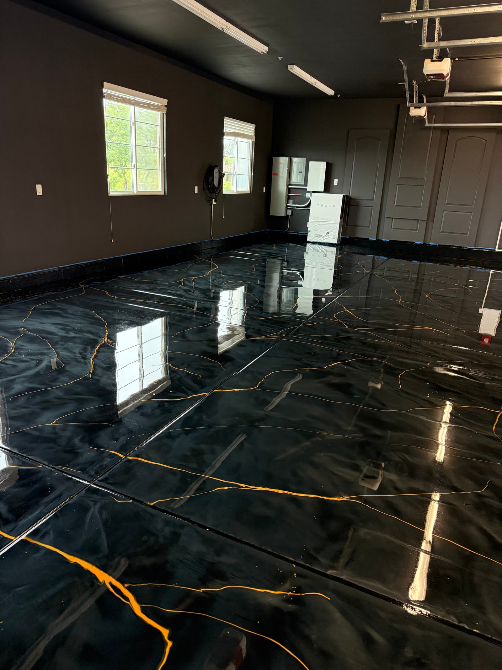 Finished black metallic epoxy garage floor with gold veining, built to match a customer's AI-generated design