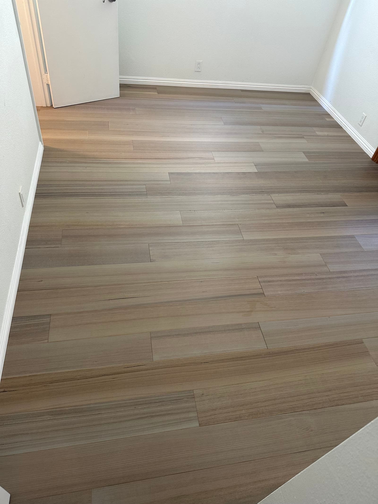 Gray-taupe luxury vinyl plank floor in an empty San Diego bedroom