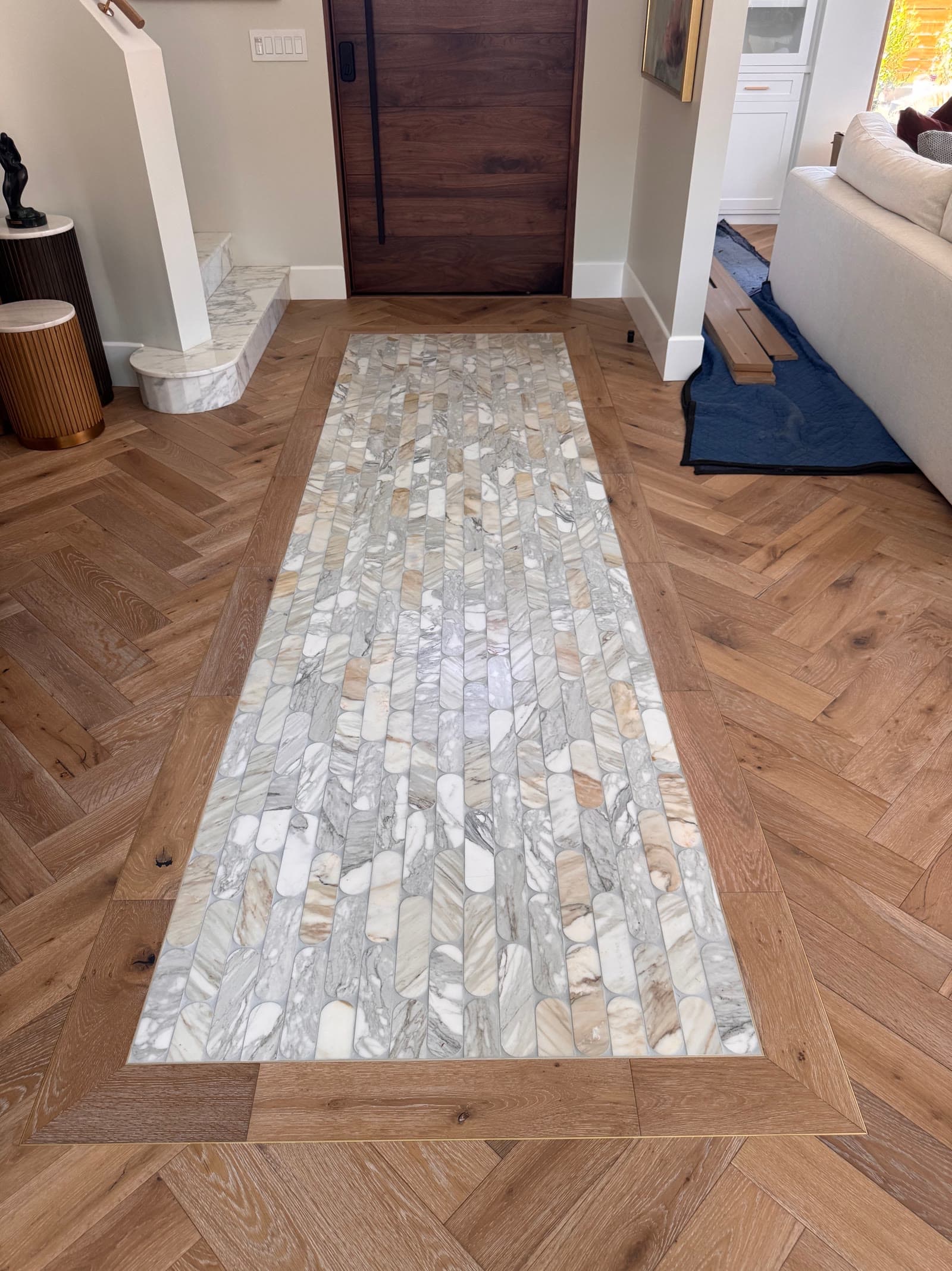 Marble mosaic inlay runner set flush into a herringbone white oak floor with a mitered oak border, Rancho Santa Fe