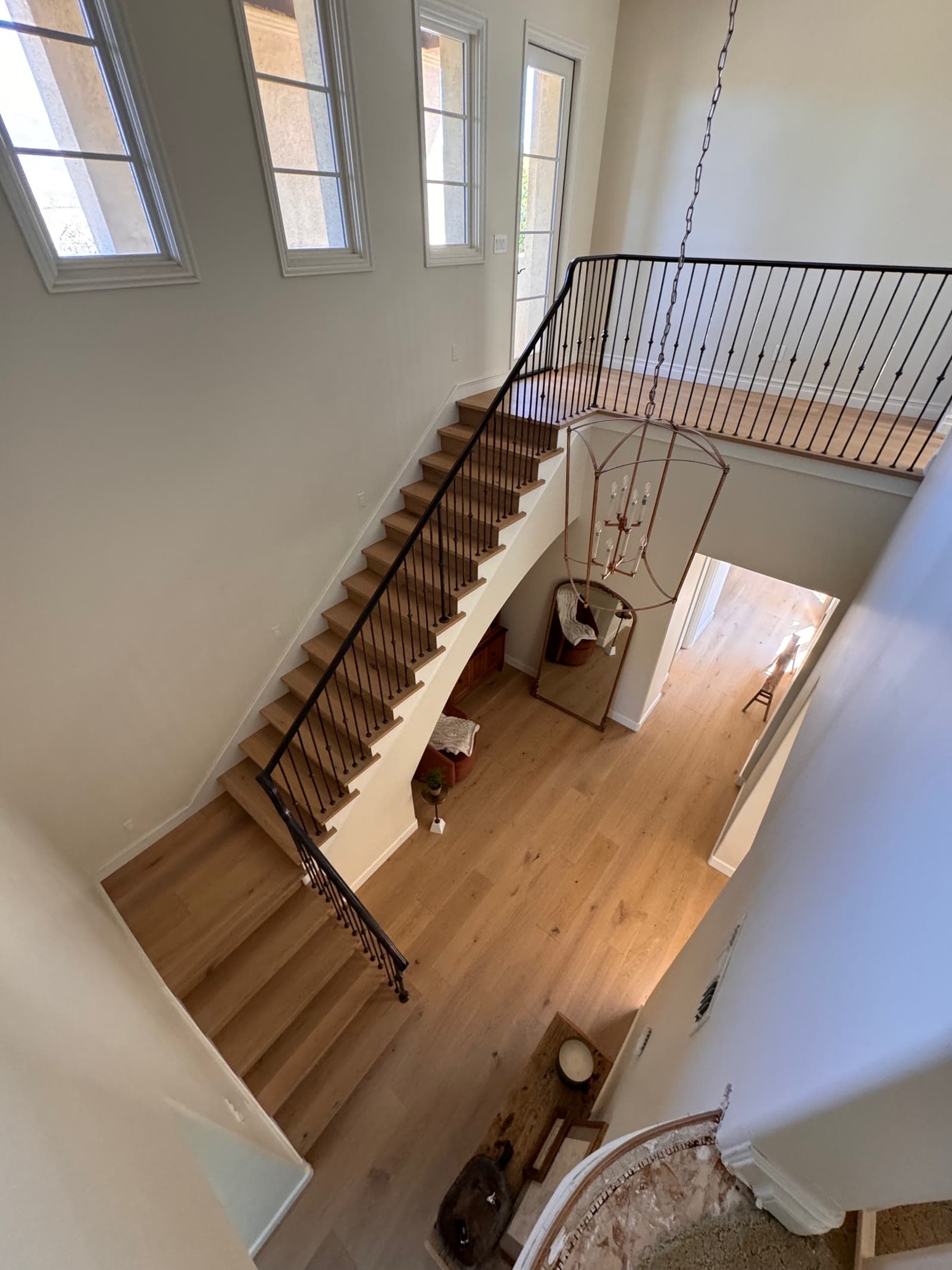 Santaluz entry hall and staircase in white oak seen from the upstairs landing