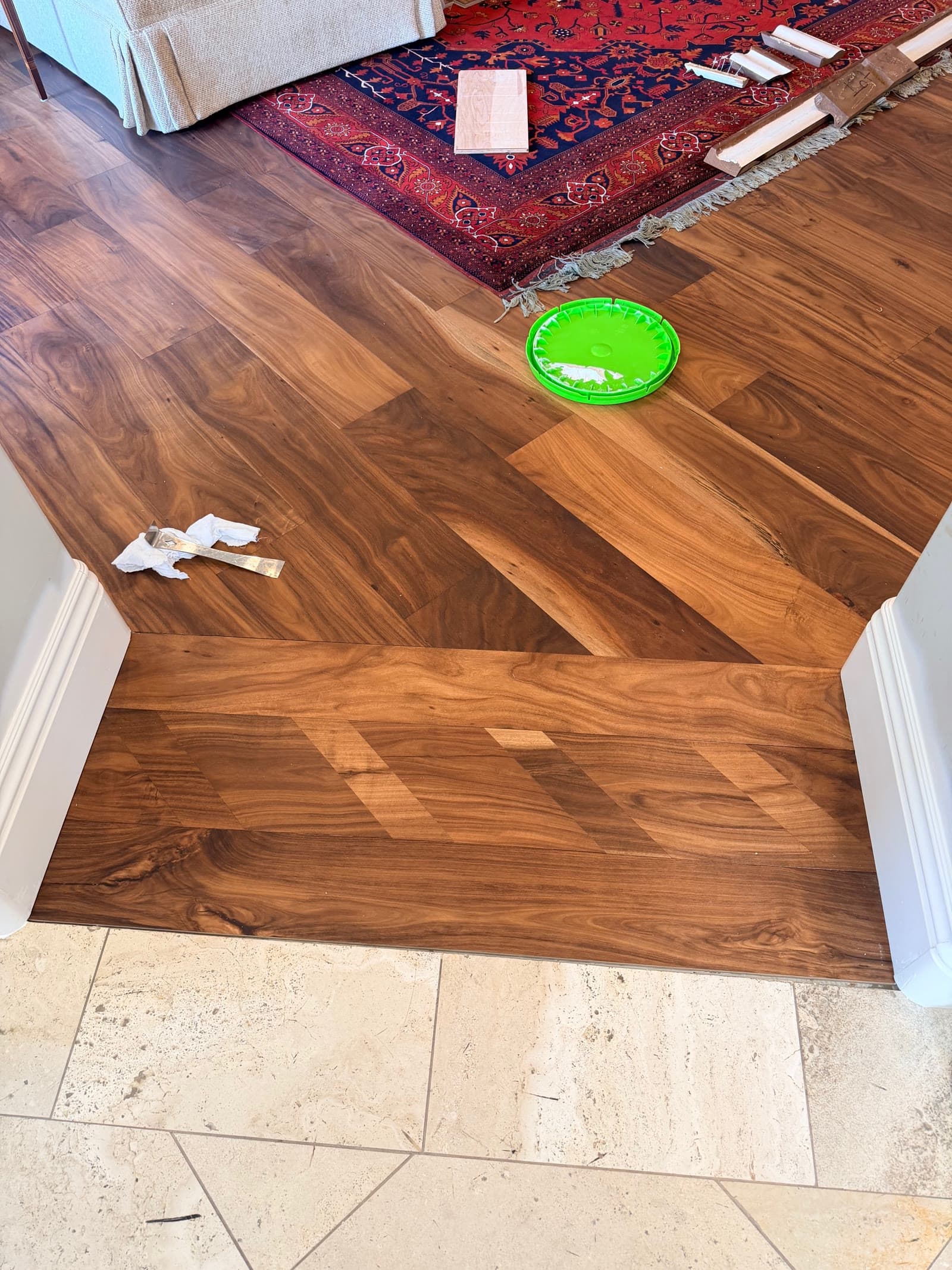 Acacia hardwood meeting travertine tile at a Carmel Valley doorway