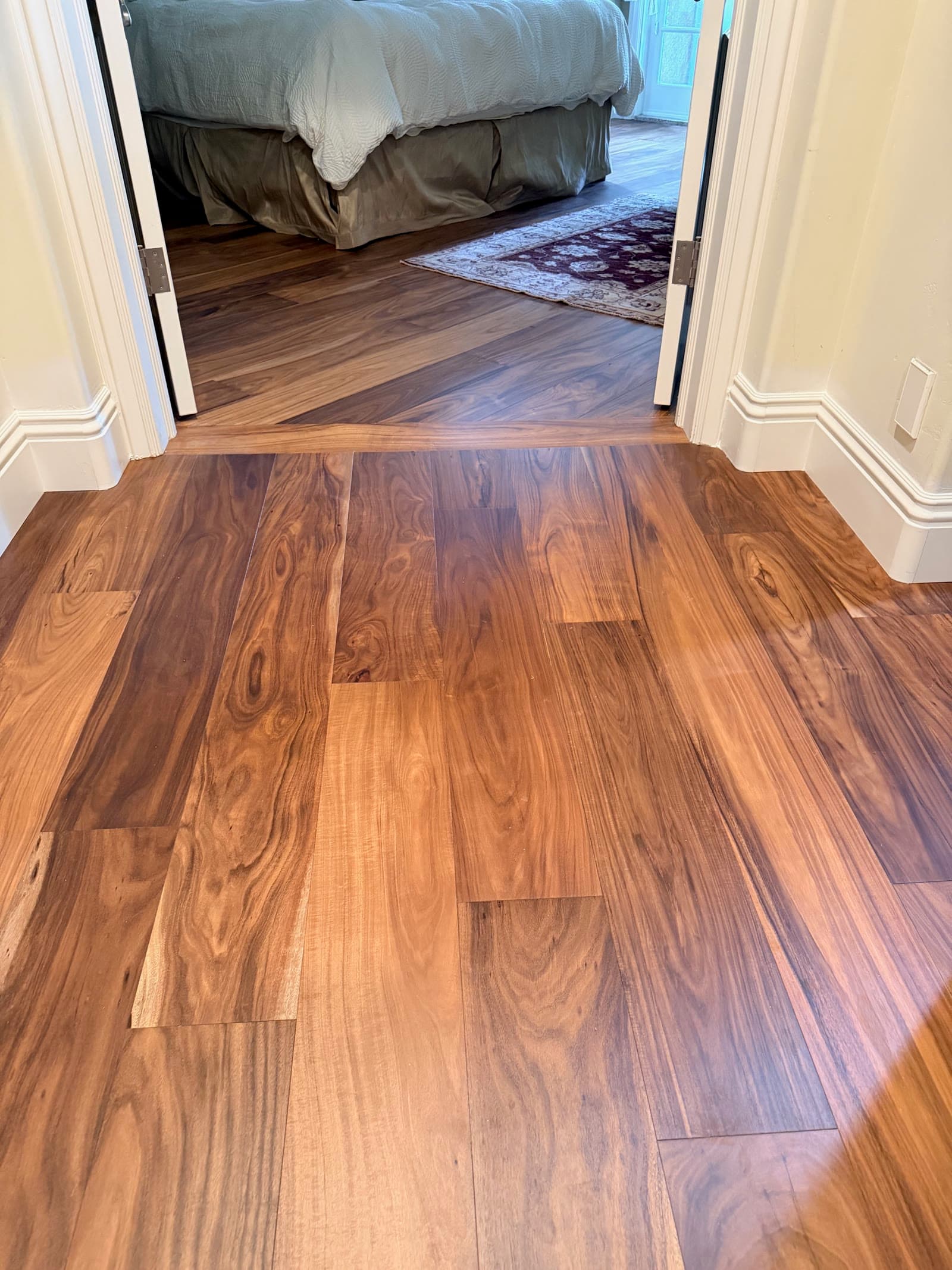 Acacia hardwood running from a hallway into a Carmel Valley bedroom