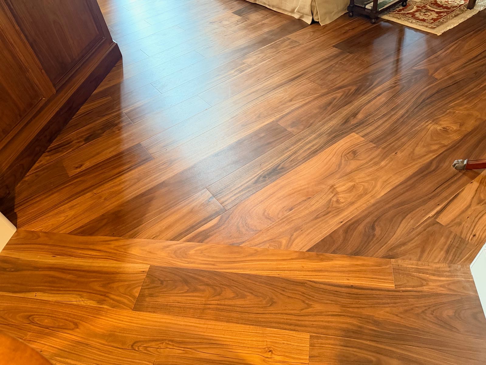 Sunlit acacia plank floor beside a dark wood cabinet in Carmel Valley