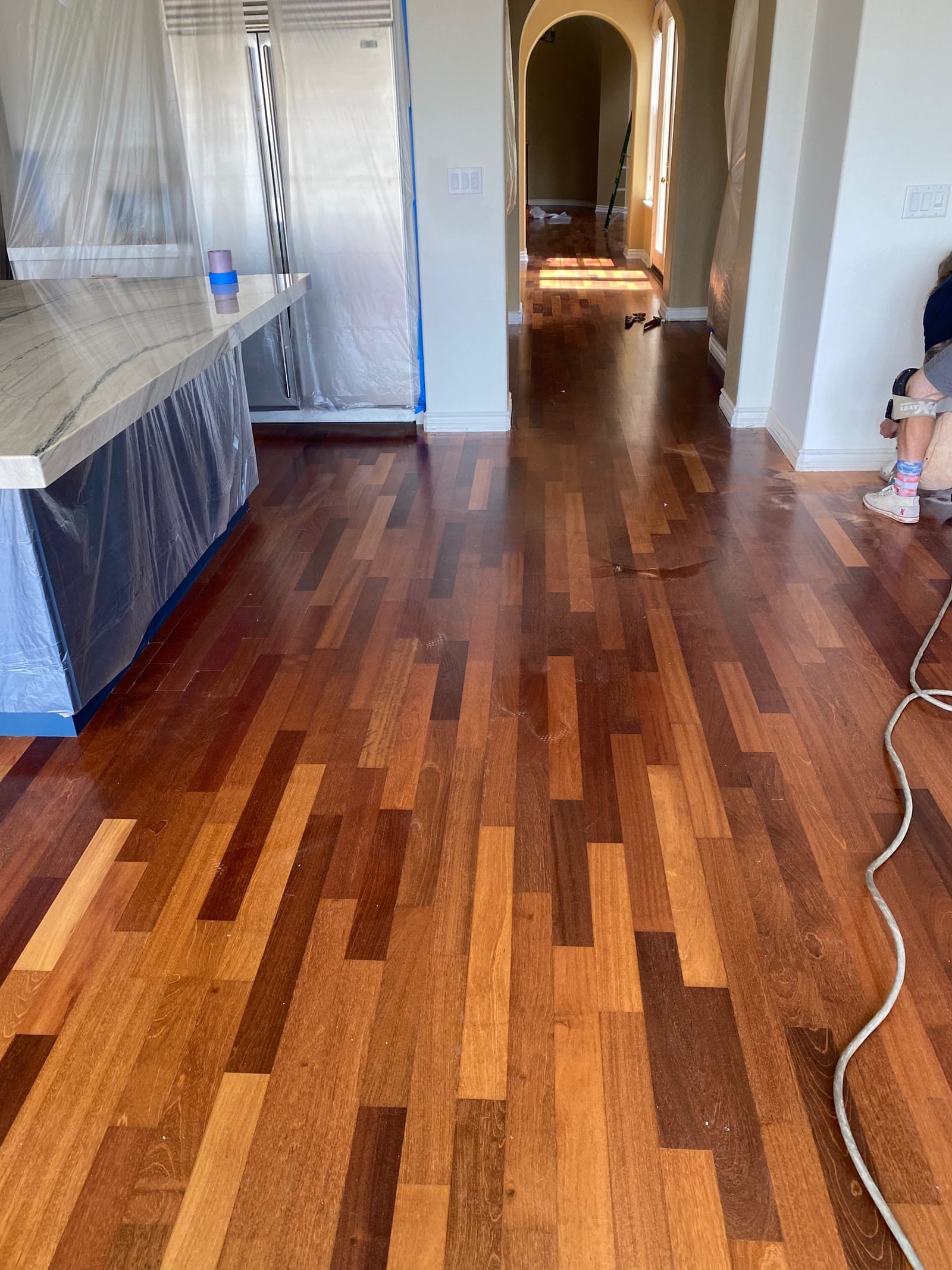Freshly finished narrow-strip Brazilian cherry floor in an Encinitas kitchen and hallway