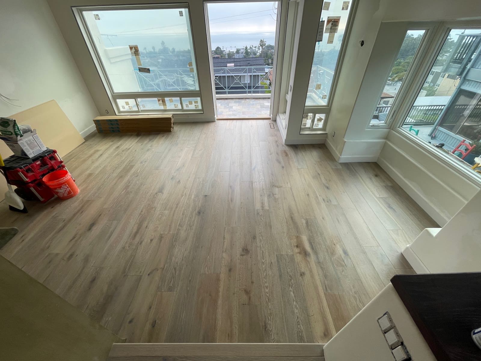 Light wire-brushed white oak plank floor in an Encinitas coastal room under construction