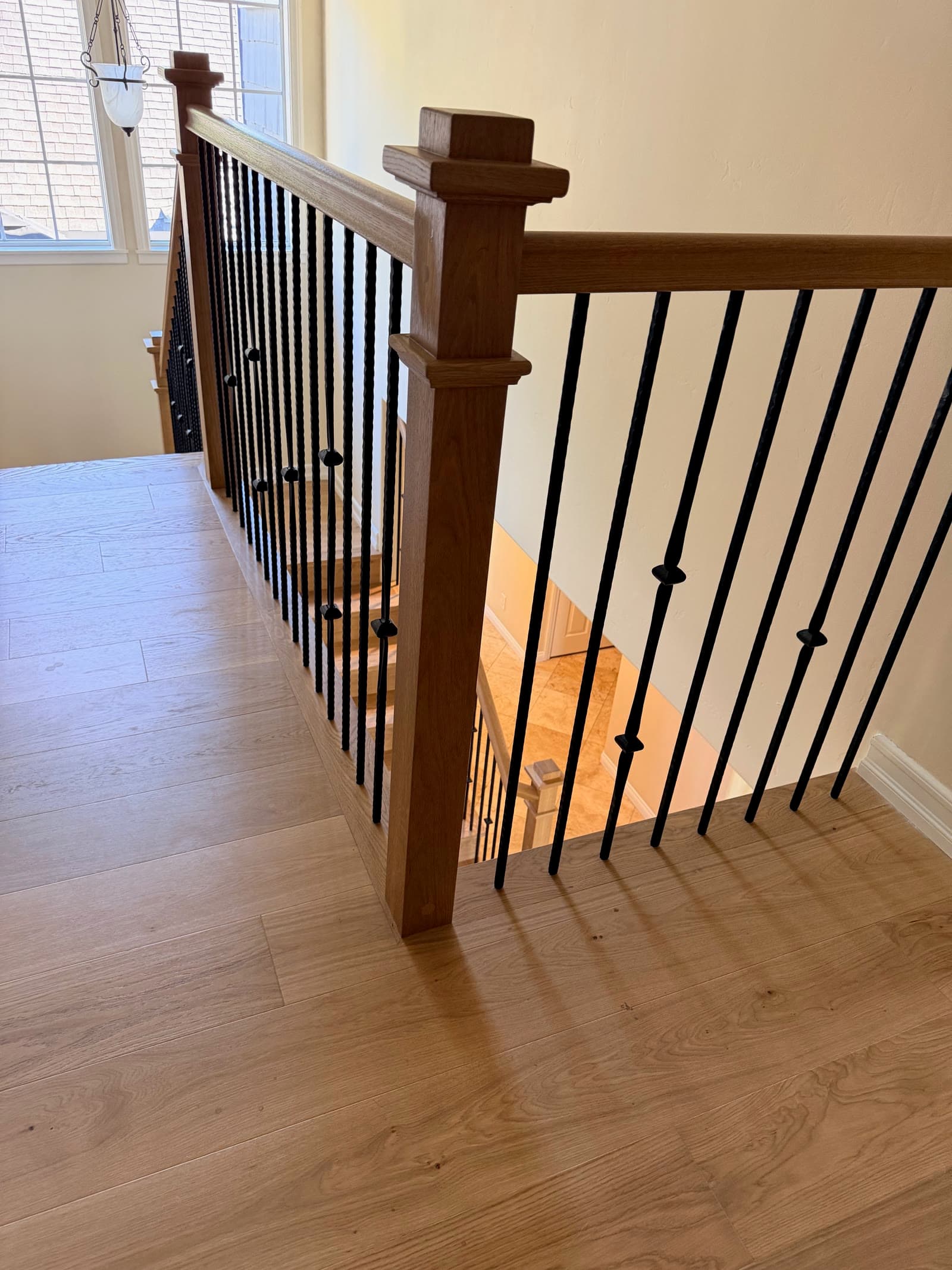 Upstairs landing in light white oak with an oak newel post and black twisted iron balusters