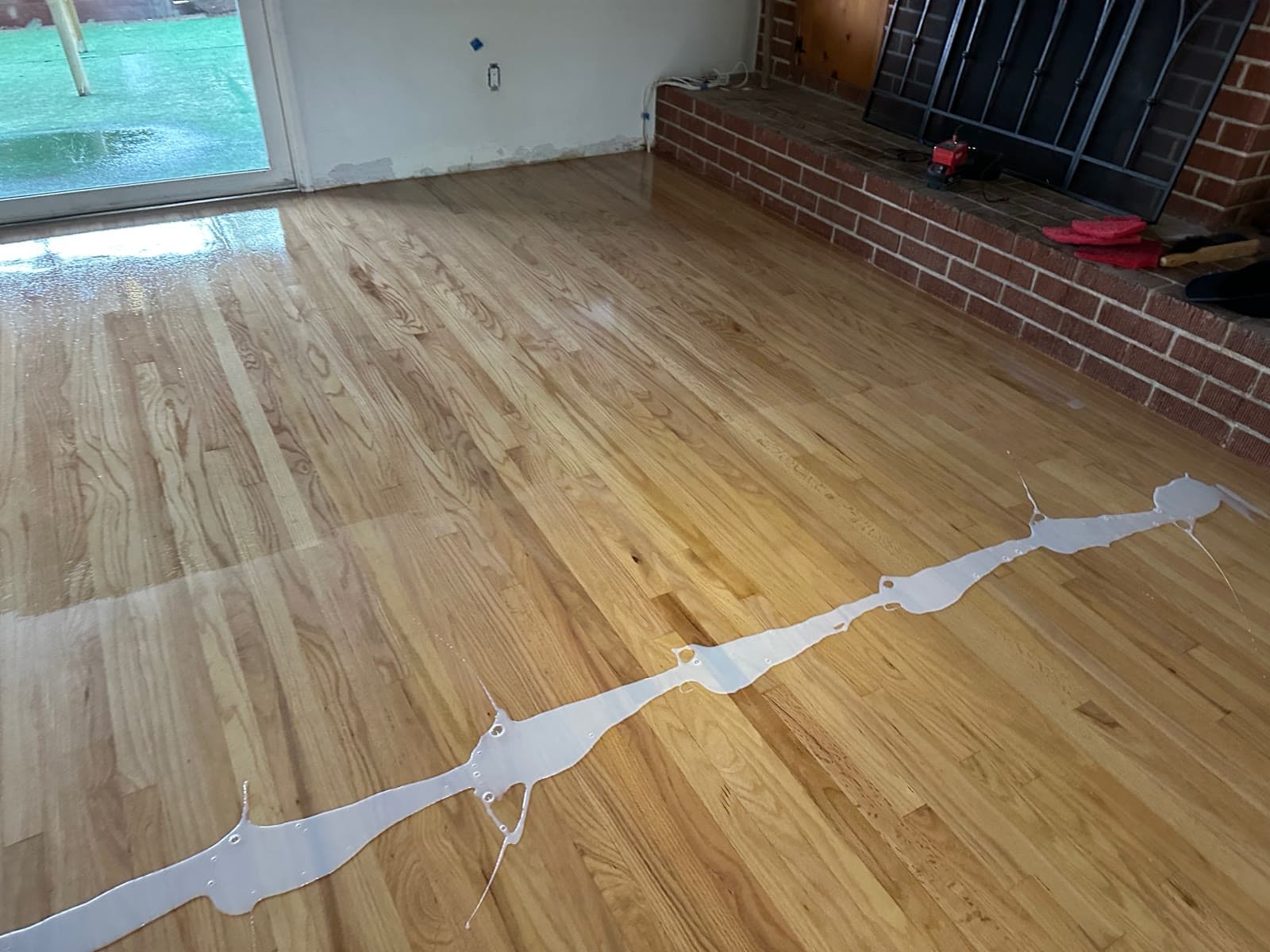 Wet coat of finish being drawn across a red oak floor in La Jolla