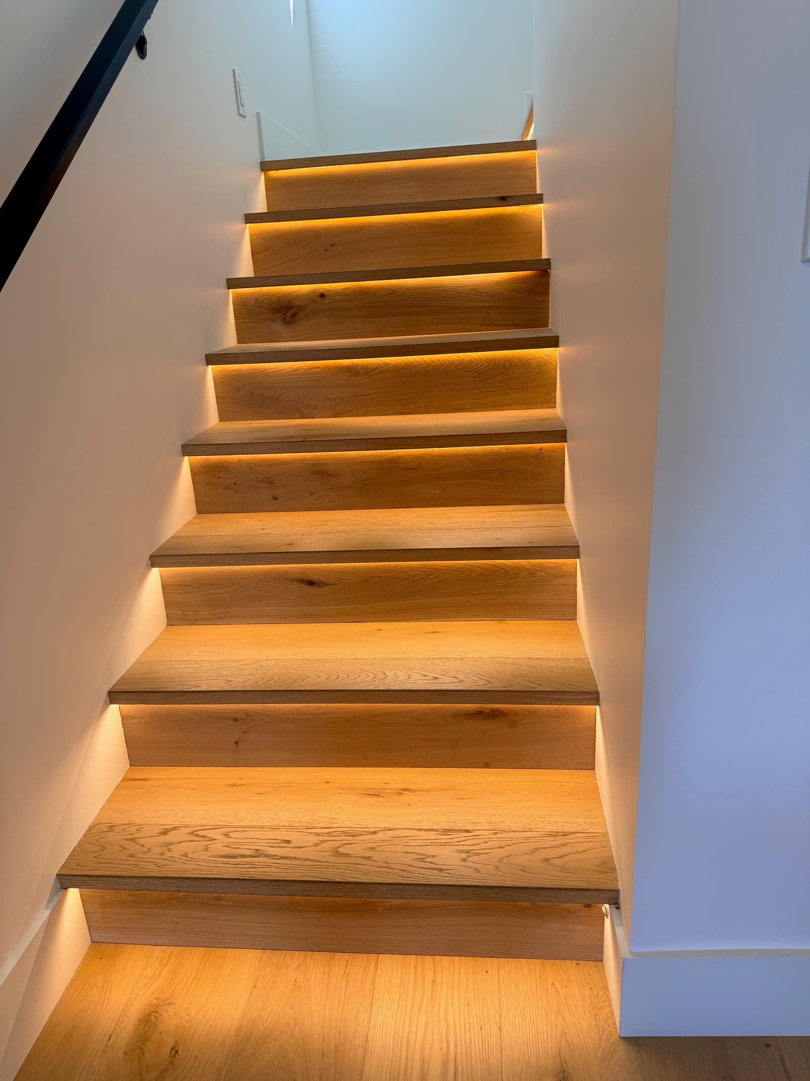 White oak stair treads lit by LED strips under each nosing in a La Jolla home