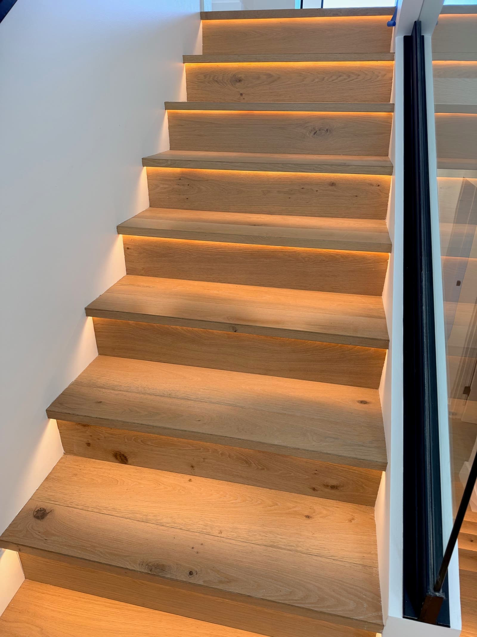 Close view of LED-lit white oak treads and risers on a modern La Jolla staircase