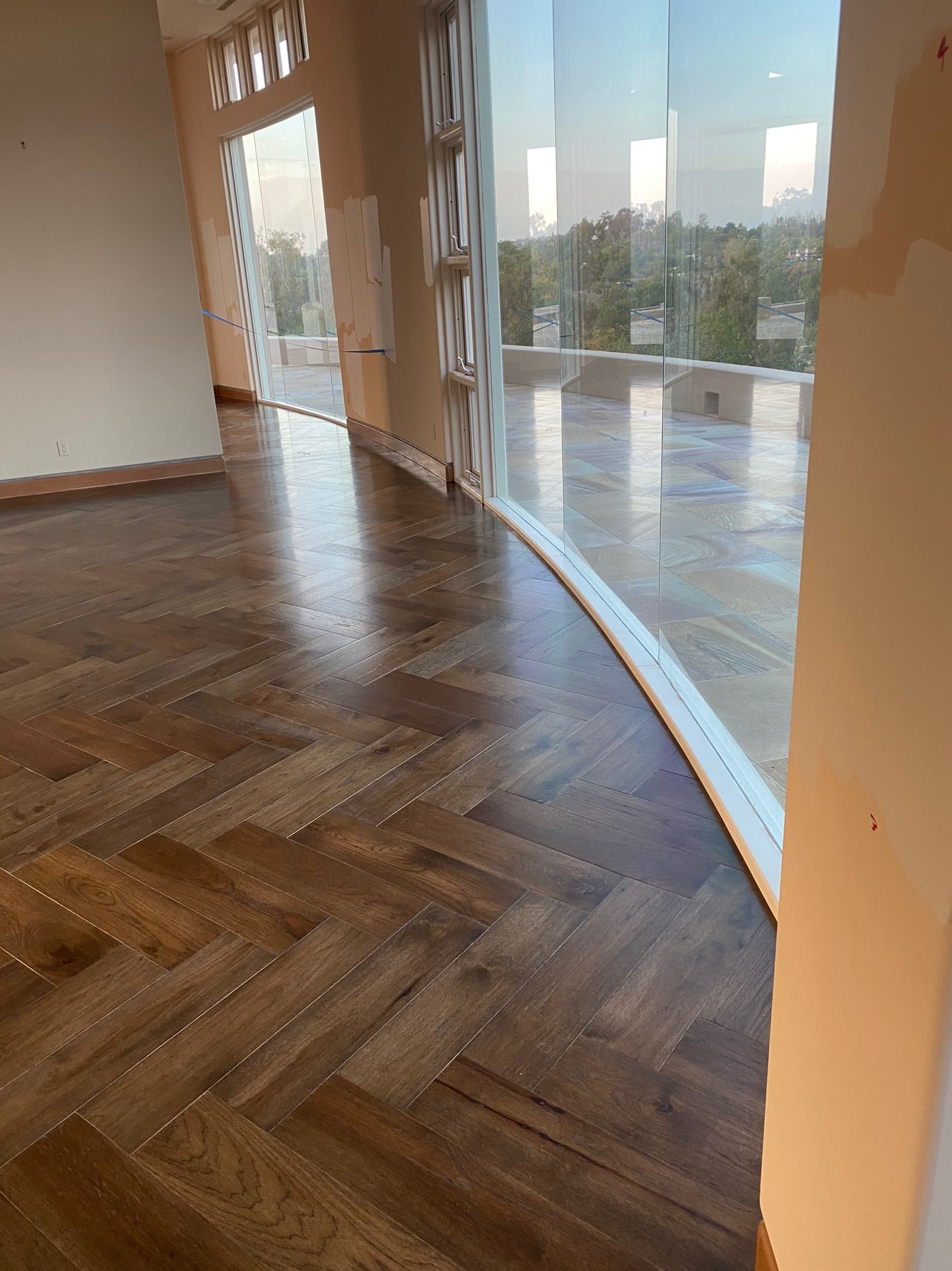 Herringbone floor cut to follow a curved wall of glass onto a stone terrace, Rancho Santa Fe