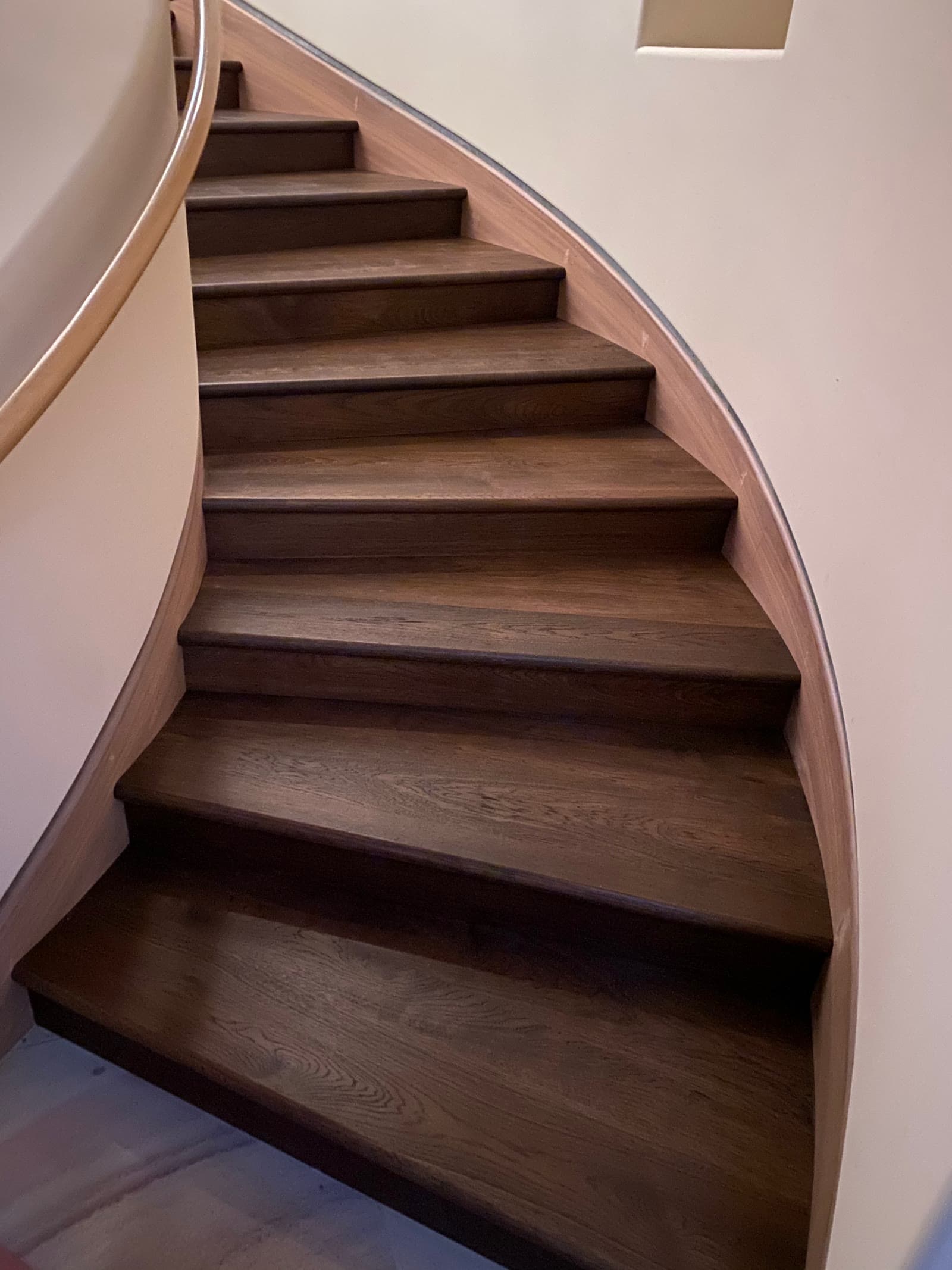 Curved staircase with dark-stained white oak treads and winders, Rancho Santa Fe
