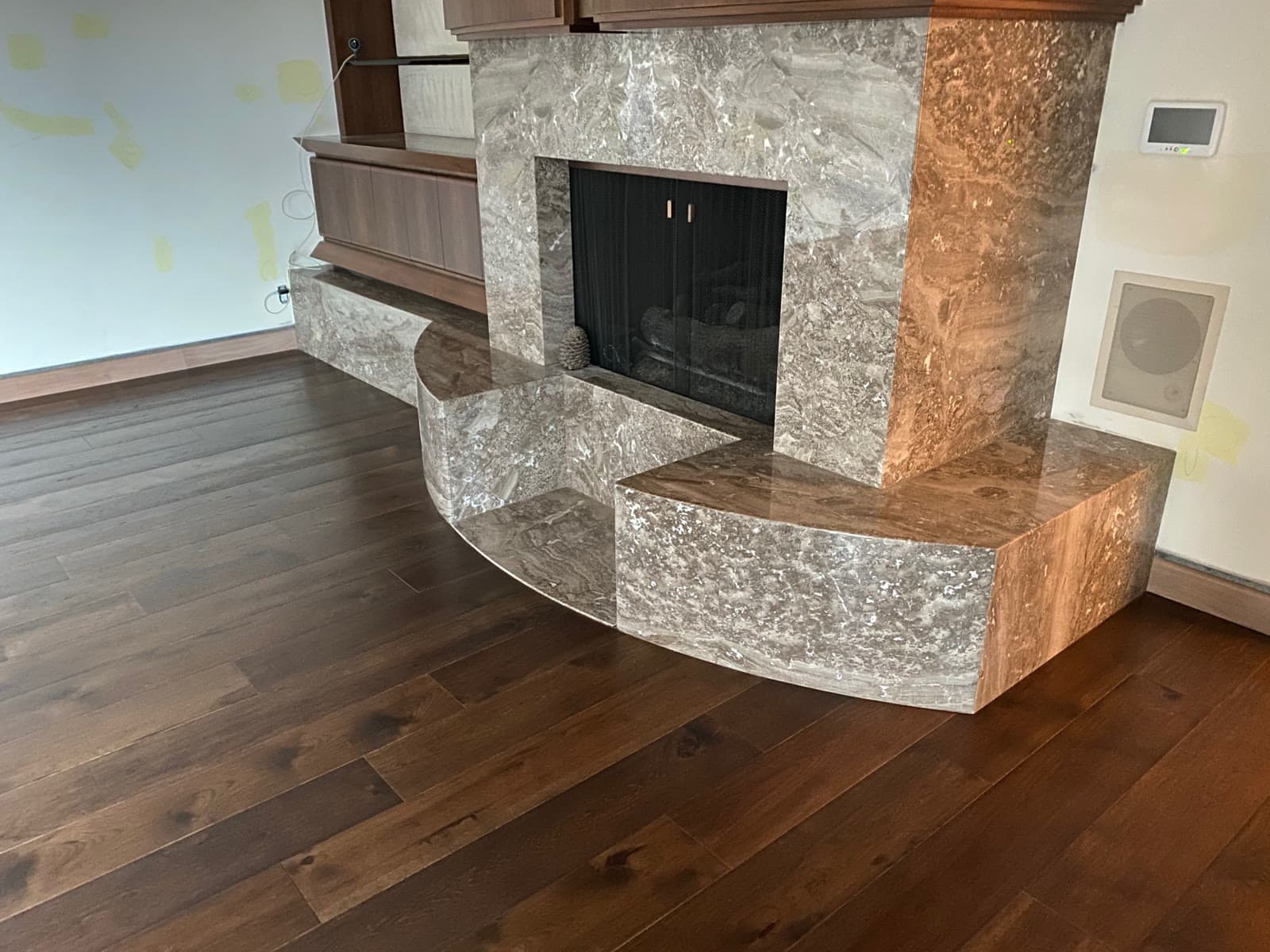 Dark wide-plank hardwood floor around a marble fireplace surround and raised hearth in Rancho Santa Fe