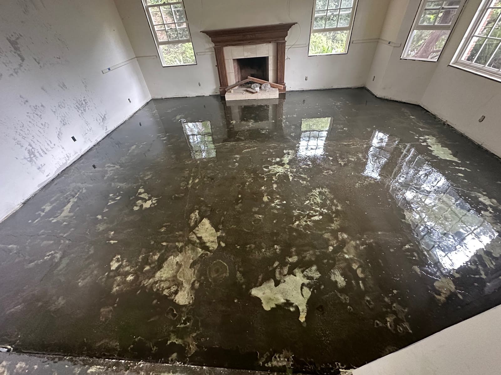 Dark moisture-barrier membrane troweled over a leveled slab before wood goes down, Rancho Santa Fe