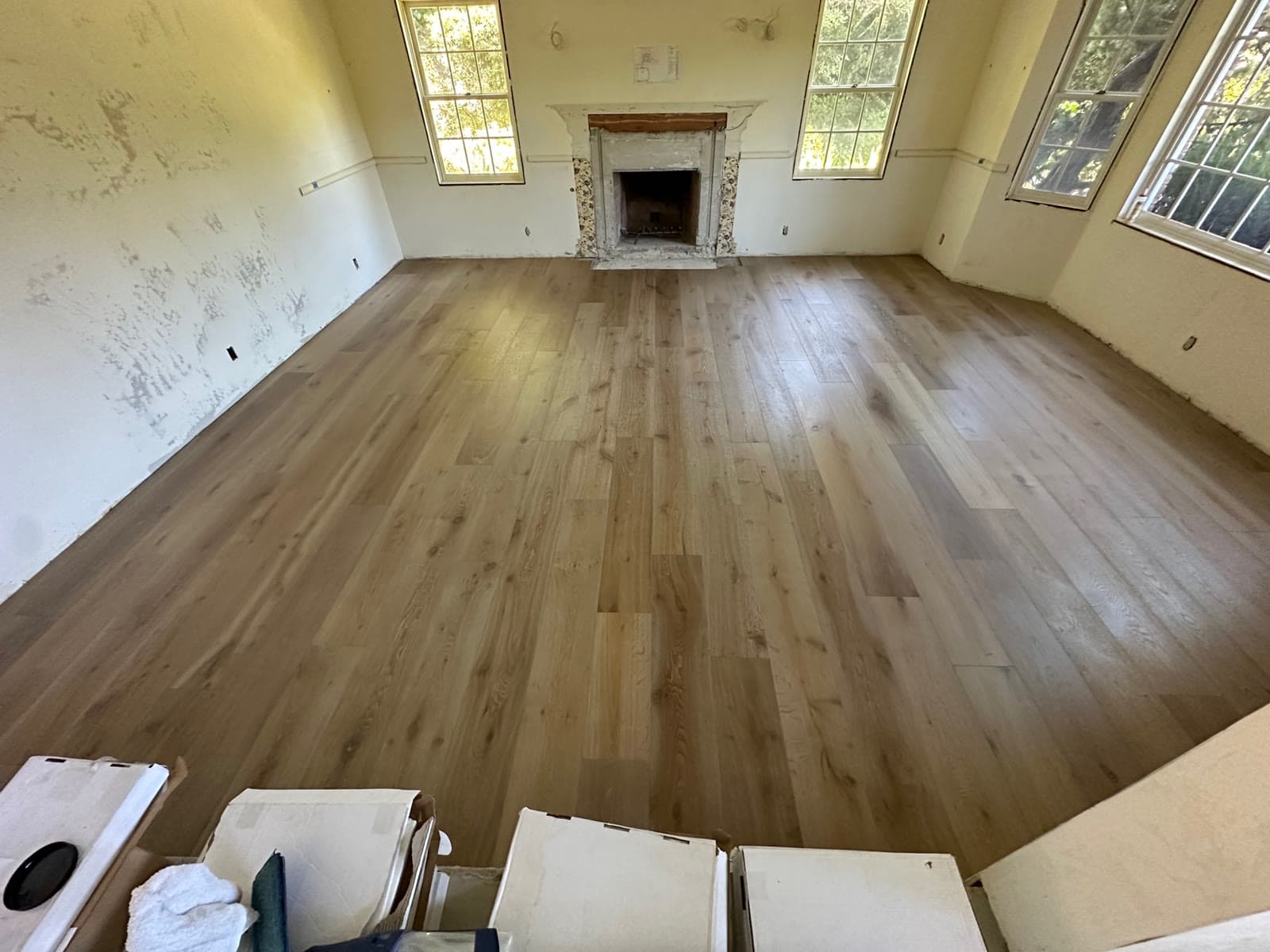 Natural light wide-plank white oak floor finished in a period Rancho Santa Fe room with a fireplace