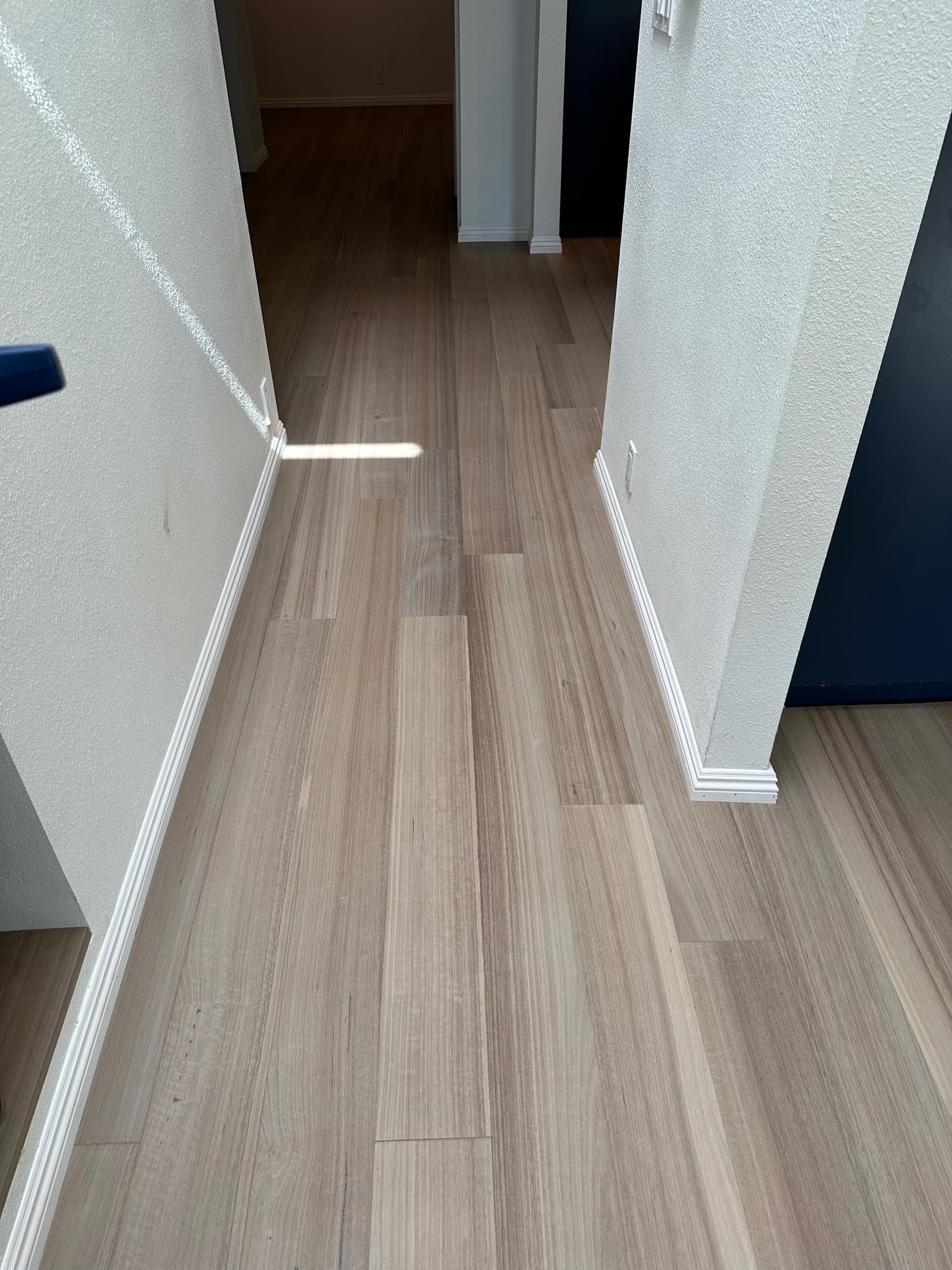Pale ash-toned plank floor running down a San Diego hallway