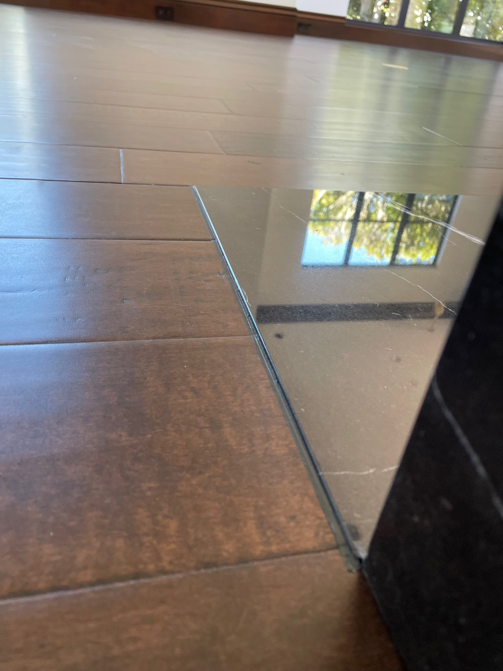 Dark hardwood floor meeting a frameless glass partition