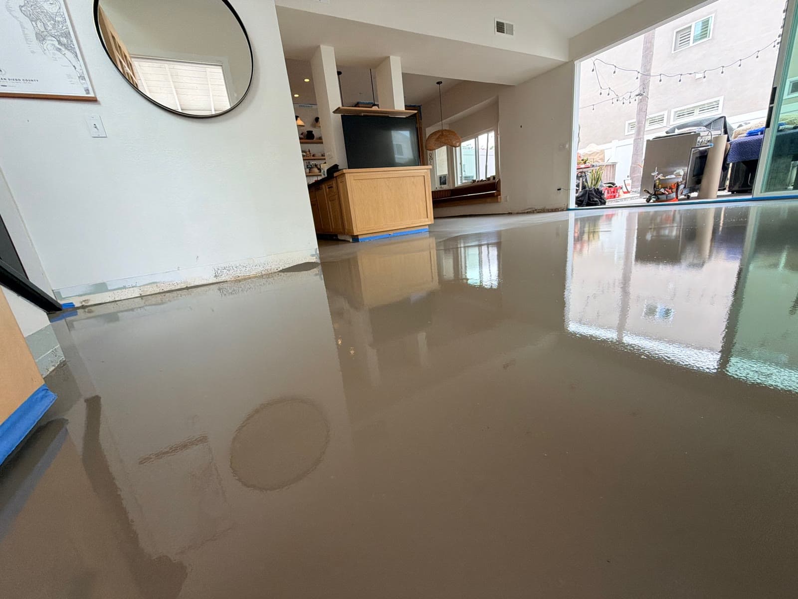 Wet self-leveling compound reflecting an open-plan kitchen and living room