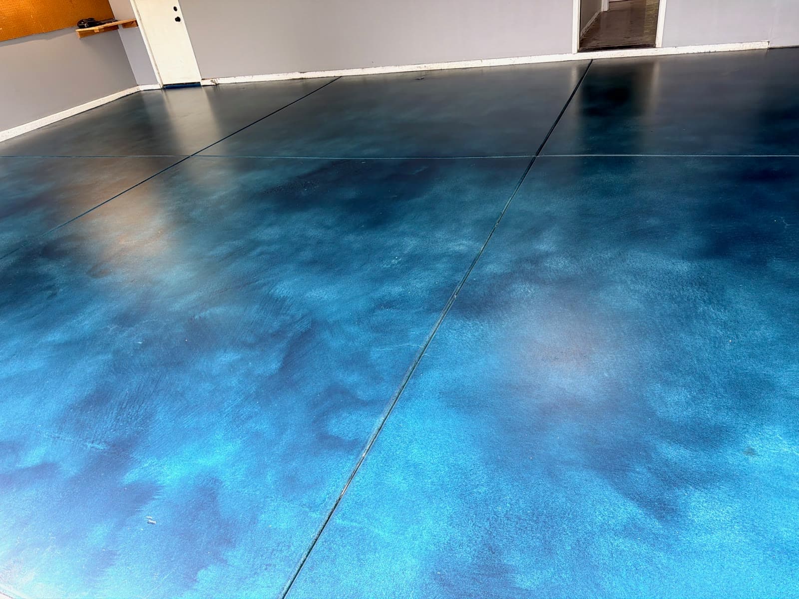 Blue acid-stained concrete garage floor with a sealed satin finish