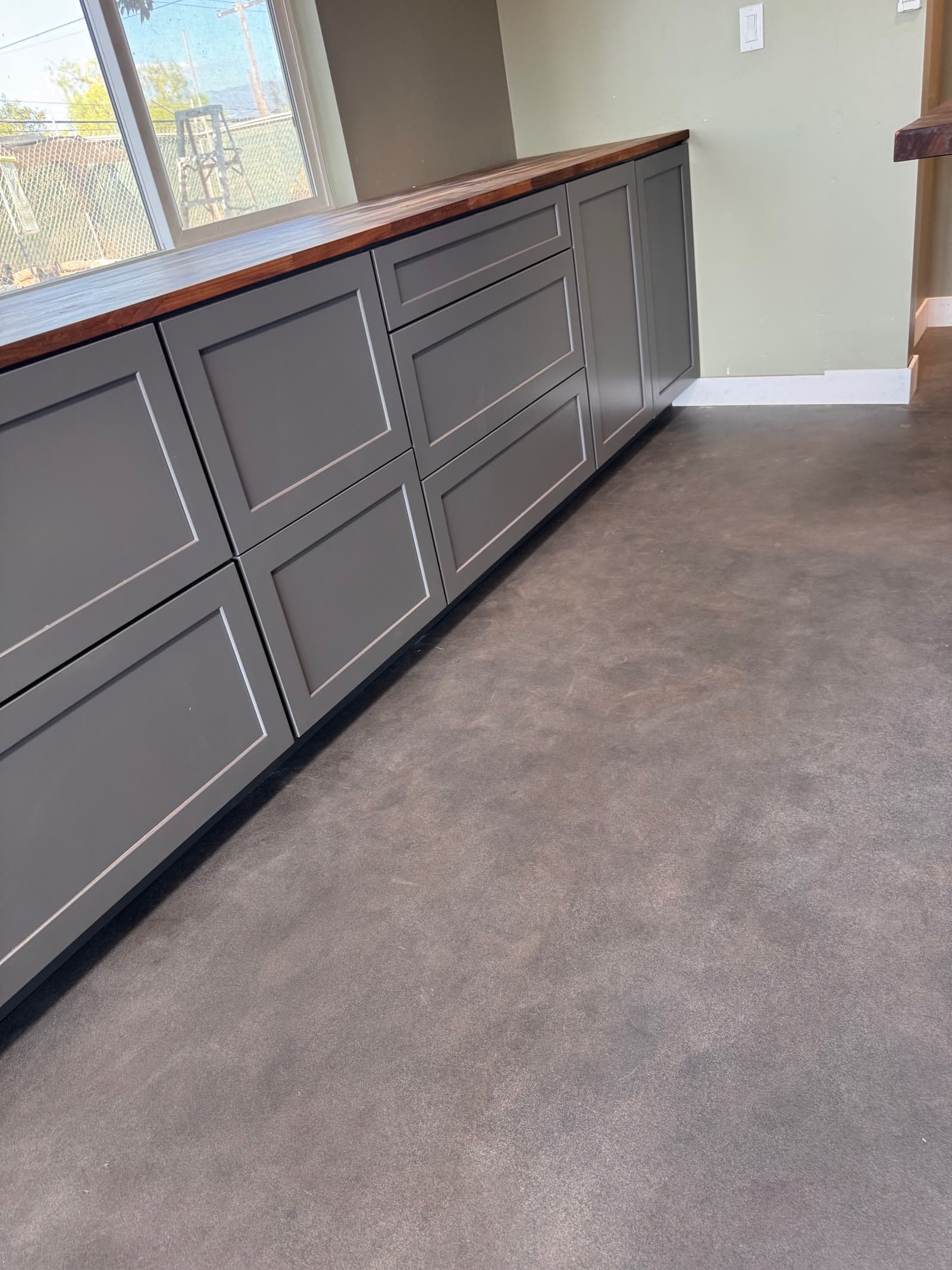Gray cabinets with a walnut top over a burnished concrete floor in Valley Center